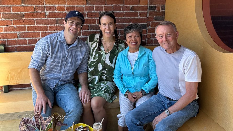 Four friends sitting together in a cozy cafe, with exposed brick walls, enjoying their time.