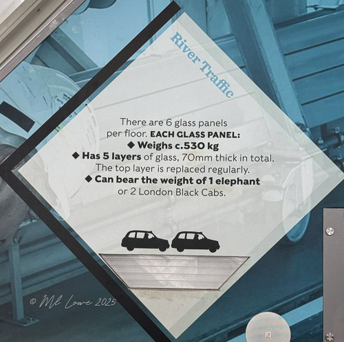 Information display about glass panels on a bridge floor, detailing weight specifications and structural features.
